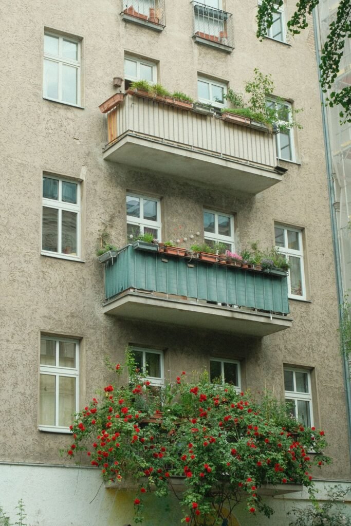 Stadsbalkon met groen hekwerk aan een gevel, plek voor een compacte balkonkast