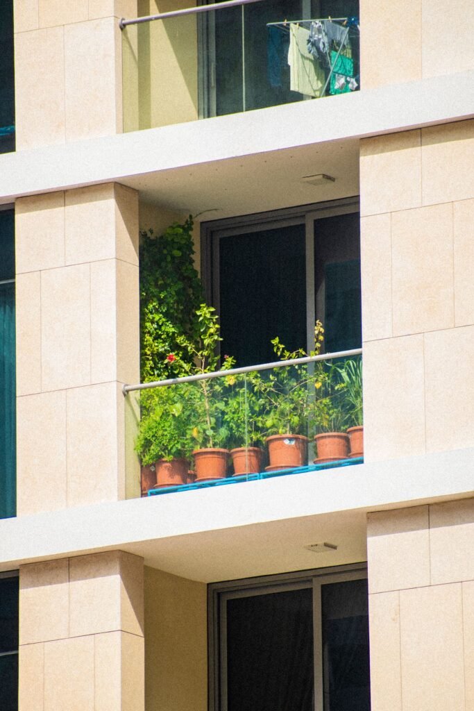 Balkon met glazen balustrade en planten in potten, plek voor een balkonkast van ikea outdoor