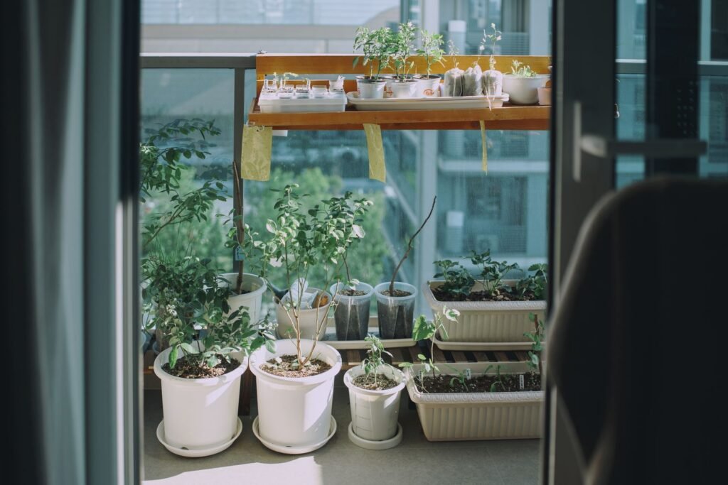 Balkon met planten in witte potten bij een raam, plek voor een balkonkast kunststof hoog