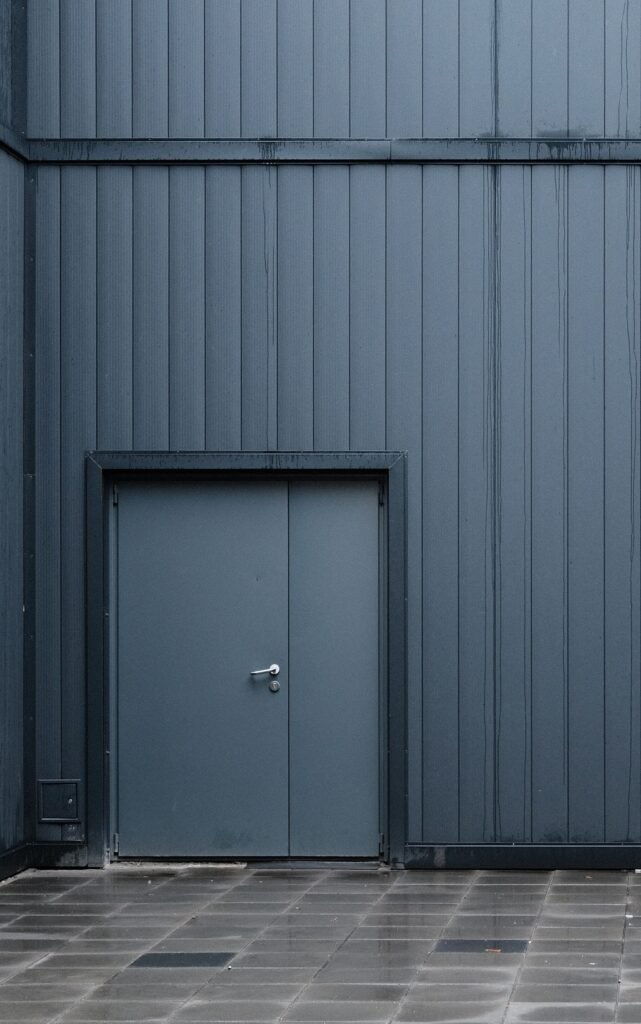 Donkergrijze metalen gevel met deur, kleur zoals een biohort tuinkast in donkergrijs metallic