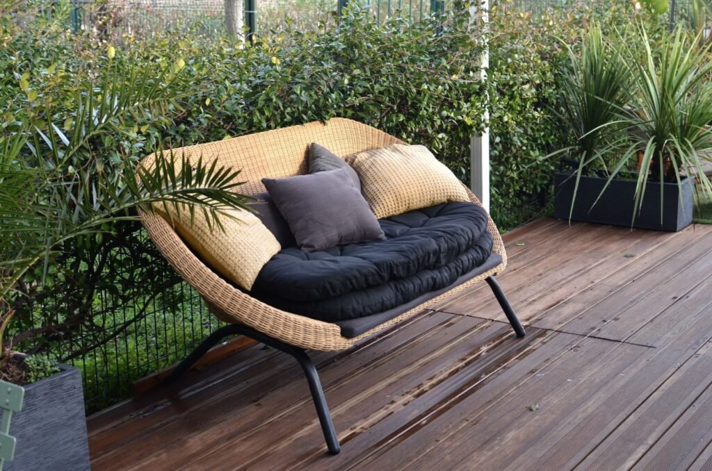 Loungebank met donkere kussens op een houten terras, kussens voor een keter opbergbox novel van leen bakker