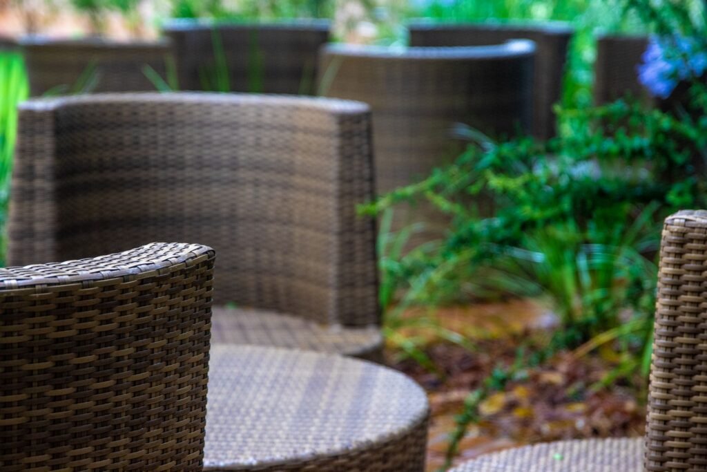Rieten tuinstoelen met kussens op een terras, kussens die passen in een kussenbox 500 liter van brico