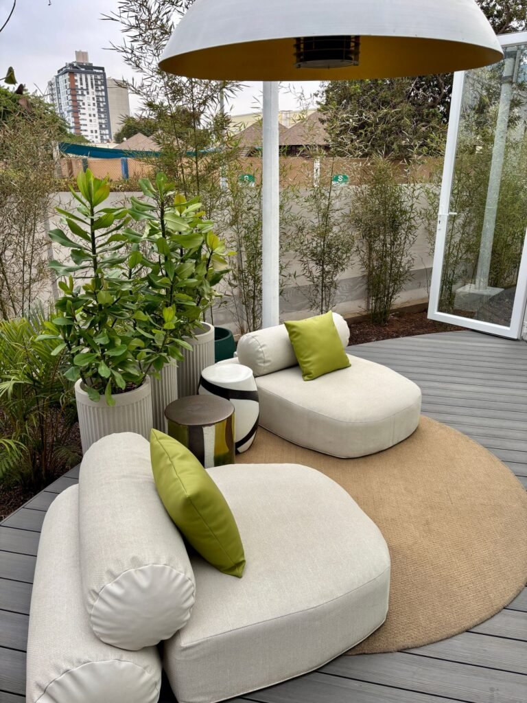 Witte loungezetels met groen kussen op een terras, loungekussens om op te bergen in een loungekussen box waterdicht pvc