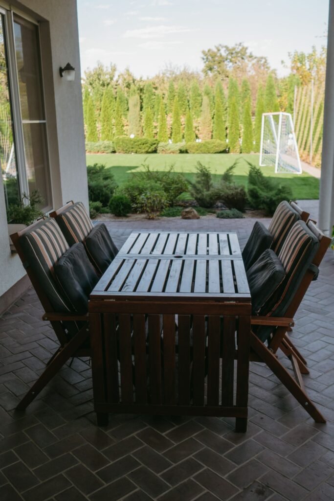 Houten tuintafel en stoelen op een terras in de tuin, met een tuinbox van action of een alternatief voor de kussens
