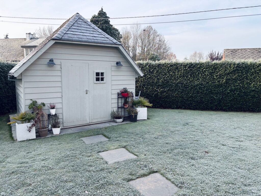 Tuinhuisje en tuin bedekt met rijp op een koude winterochtend, moment om een tuinkussen box waterdicht winterklaar te maken