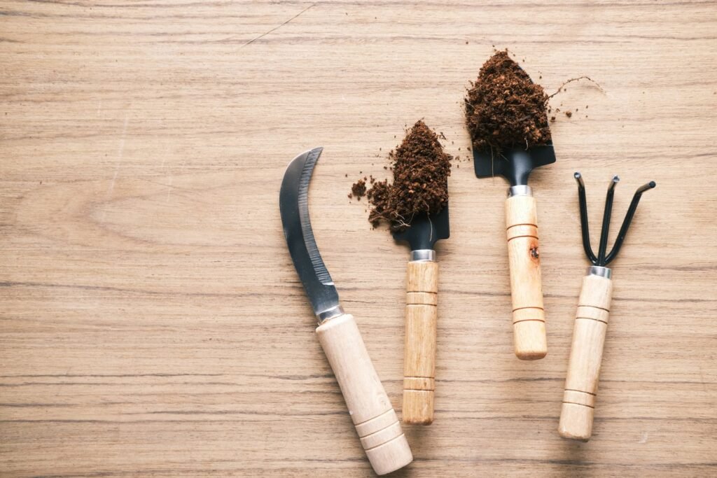 Tuingereedschap met houten handvatten op een houten ondergrond, op te bergen in een verzinkt stalen buitenkast